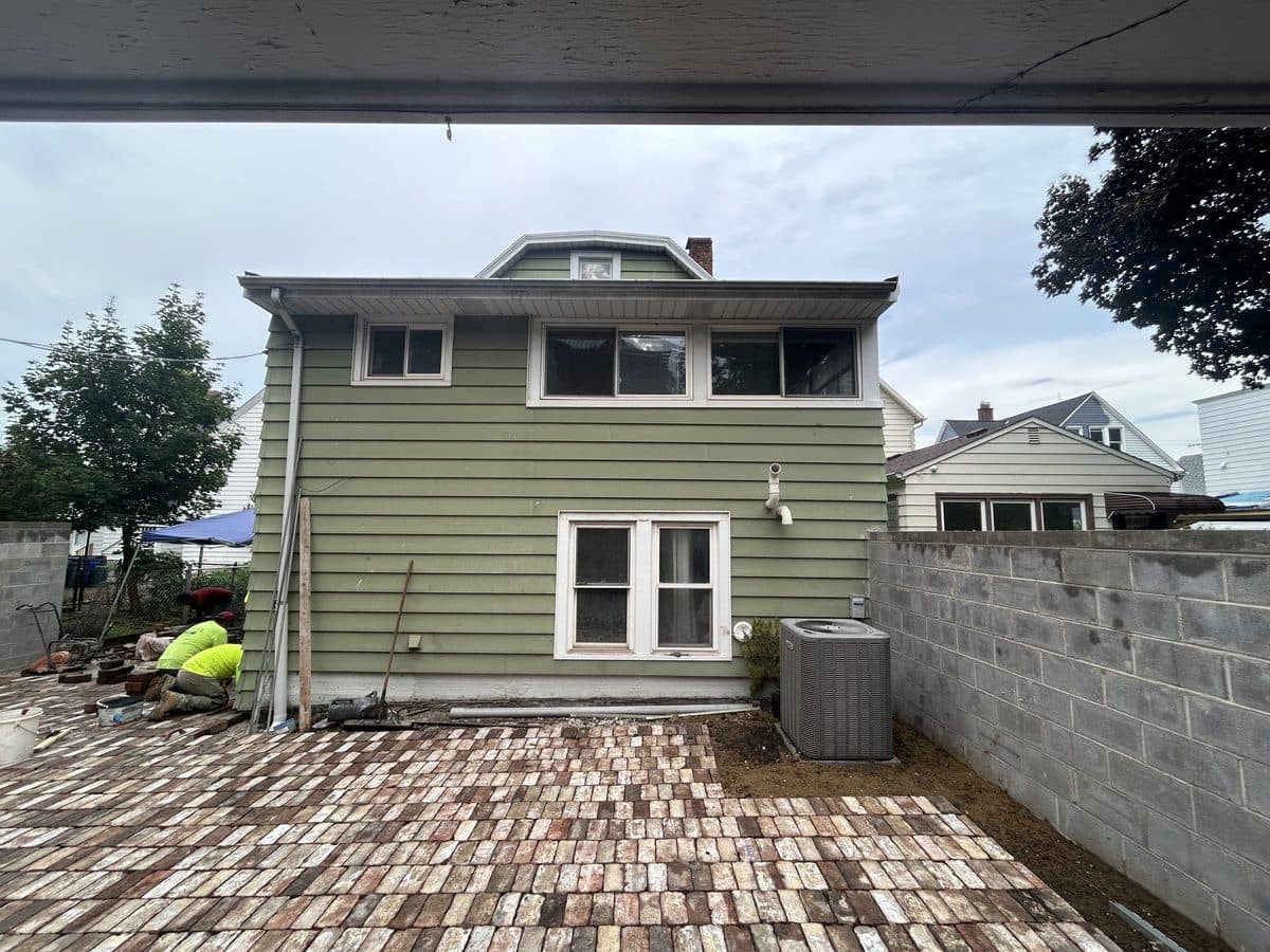 House with aged green siding before exterior repaint