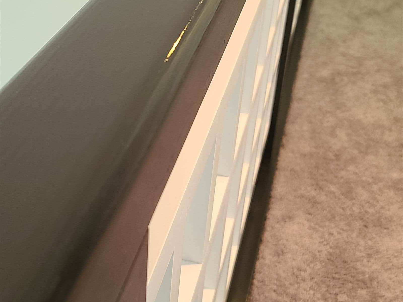 Dark-stained handrail cap over crisp white painted spindles on a restored staircase railing by Cavelli Painting