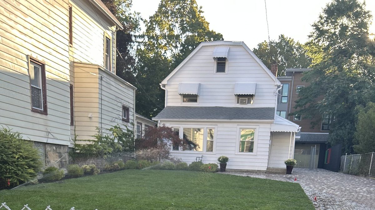 Same house repainted white with new lawn and brick paver driveway