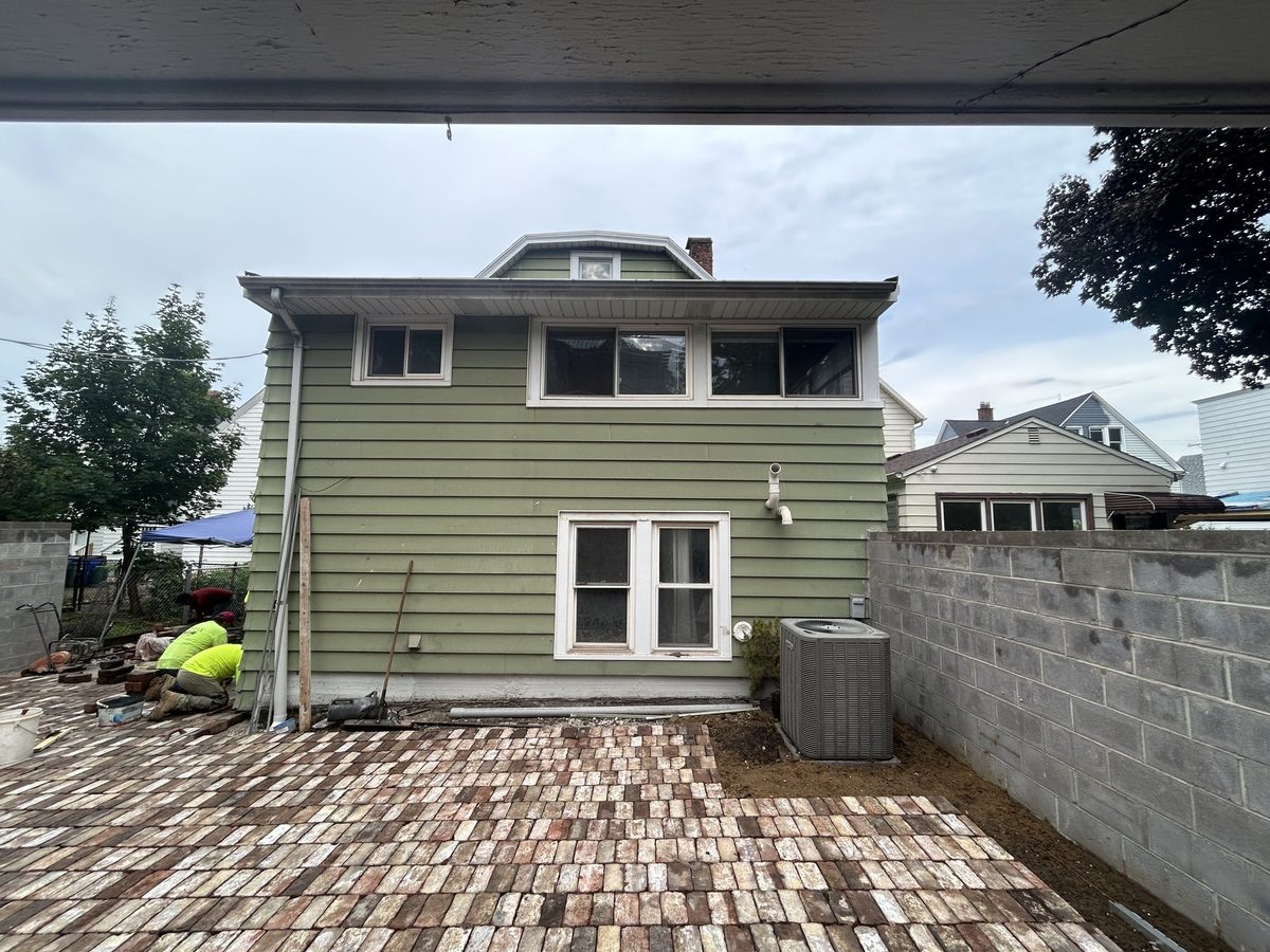 House with aged green siding before exterior repaint