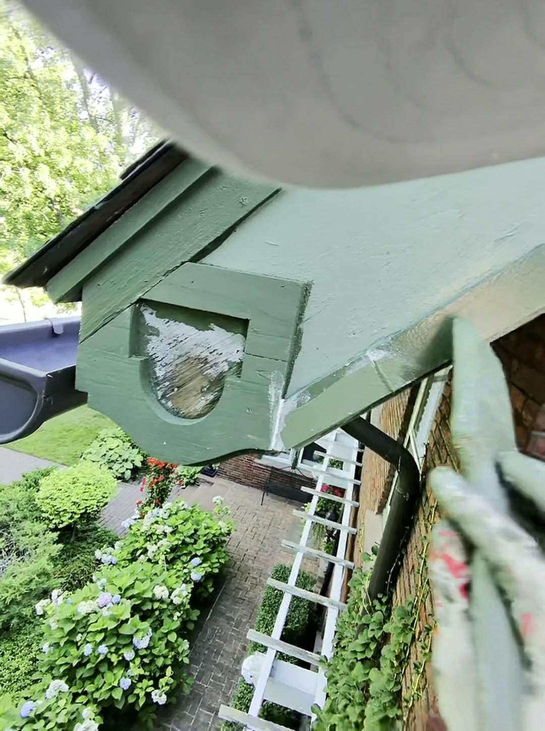 Finished decorative eave bracket rebuilt, primed, and painted green on a Cleveland Heights home