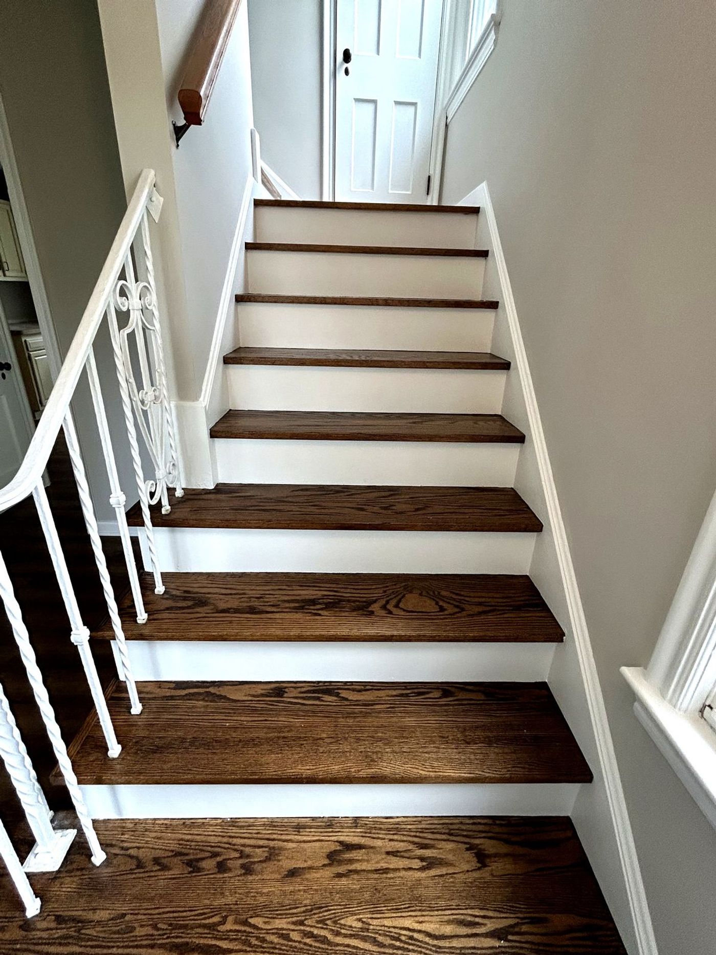Spotless finished staircase — crisp white risers and refinished oak treads after final detailing